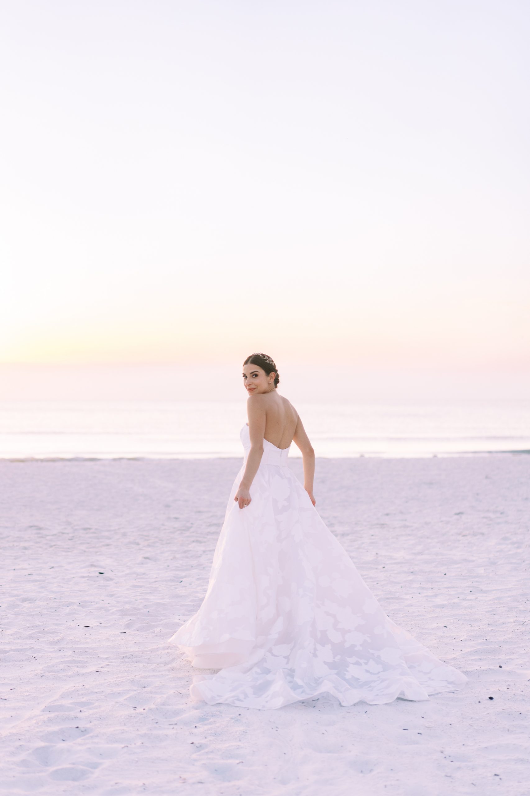 Bride on beach at sunset